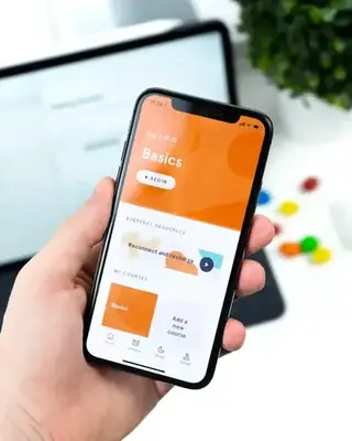 iPhone in hand showing a mobile app