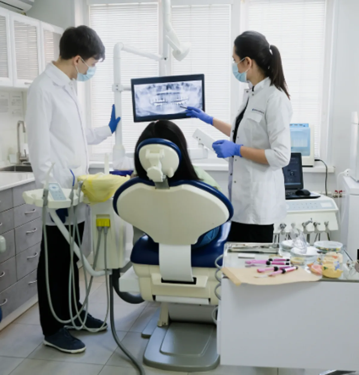 Clínica dental atendiendo a una paciente en Torre-Pacheco, con radiografía en pantalla