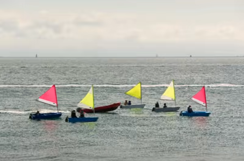 Escuela de vela con veleros de colores navegando en el Mar Menor, San Javier