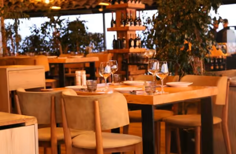 Interior de restaurante con mesas de madera puestas al atardecer en Santiago de la Ribera, San Javier