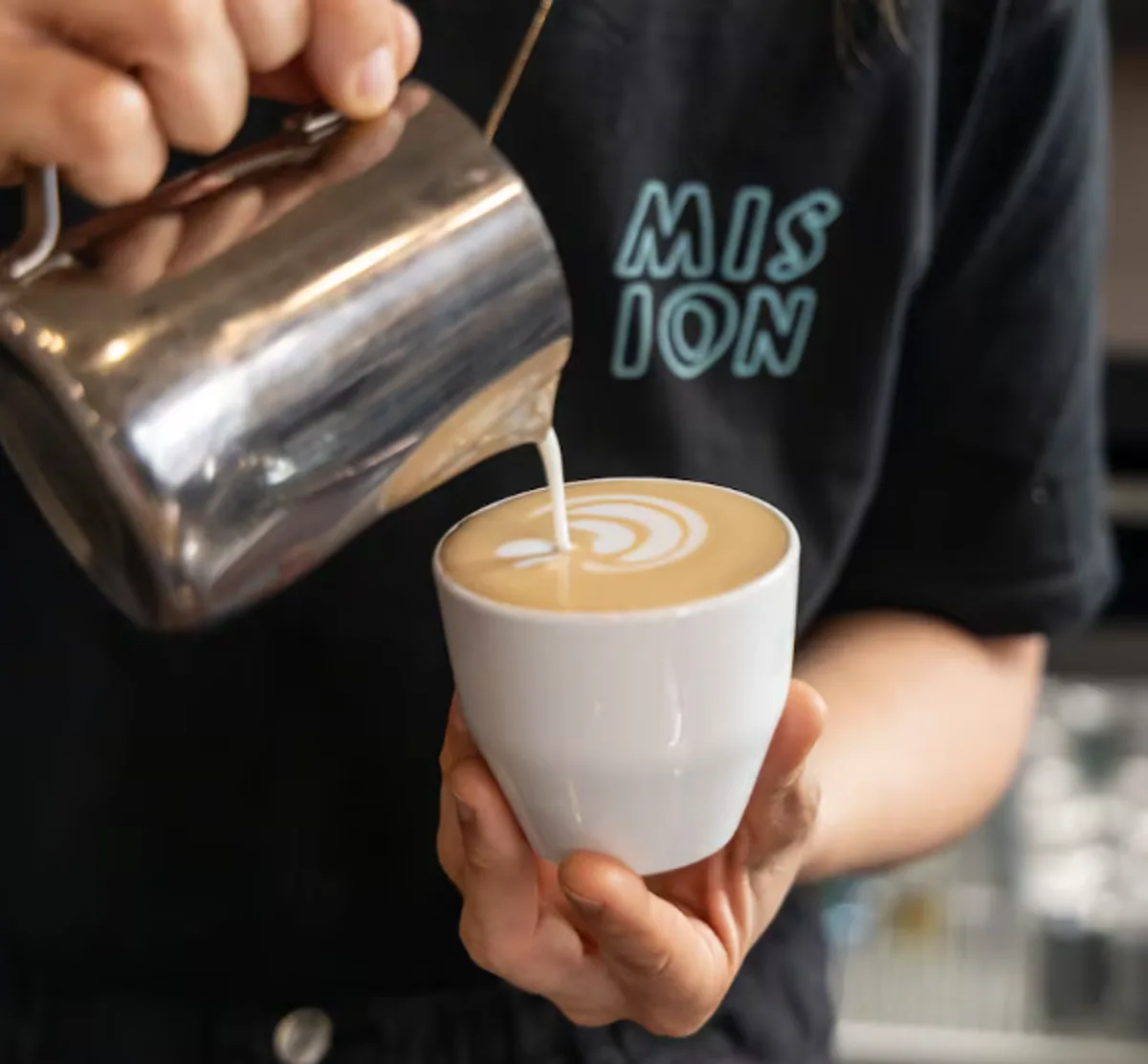 Barista sirviendo café con leche en cafetería del casco de Torre-Pacheco