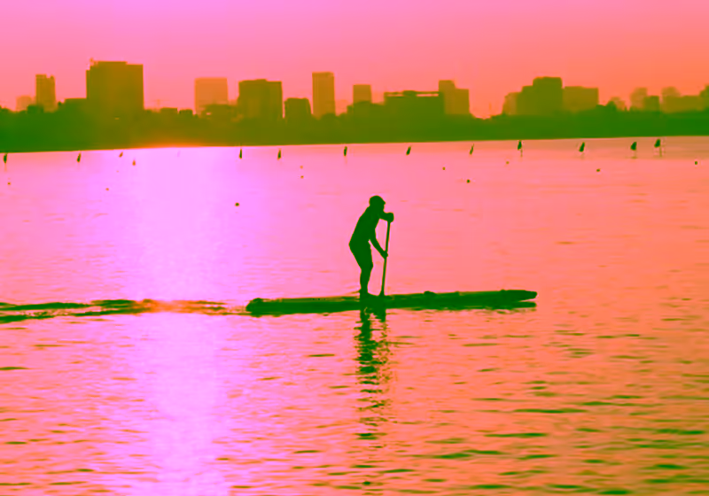 Practicante de paddle surf al atardecer sobre las aguas tranquilas del Mar Menor en San Pedro del Pinatar